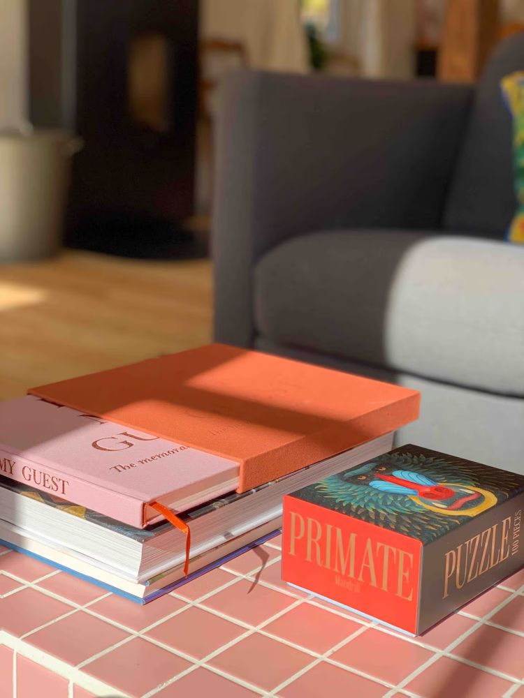 Bücher und Puzzle auf rosa Fliesentisch