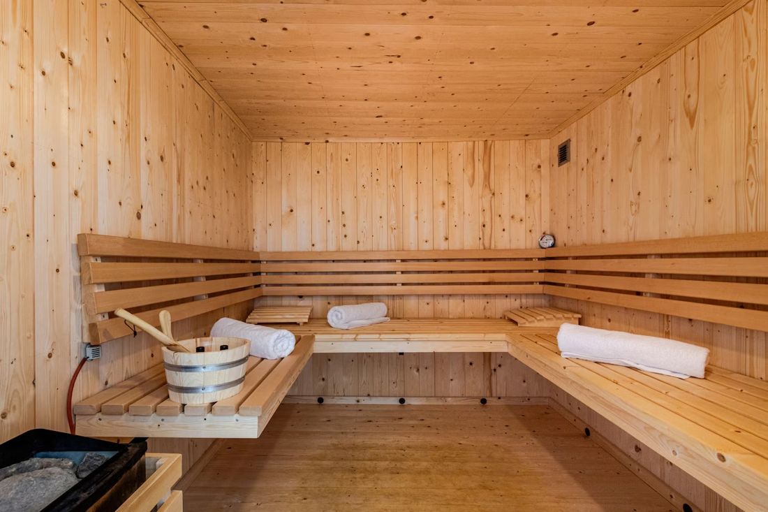 Finnische Sauna aus hellem Holz mit Handtüchern und Saunakübel