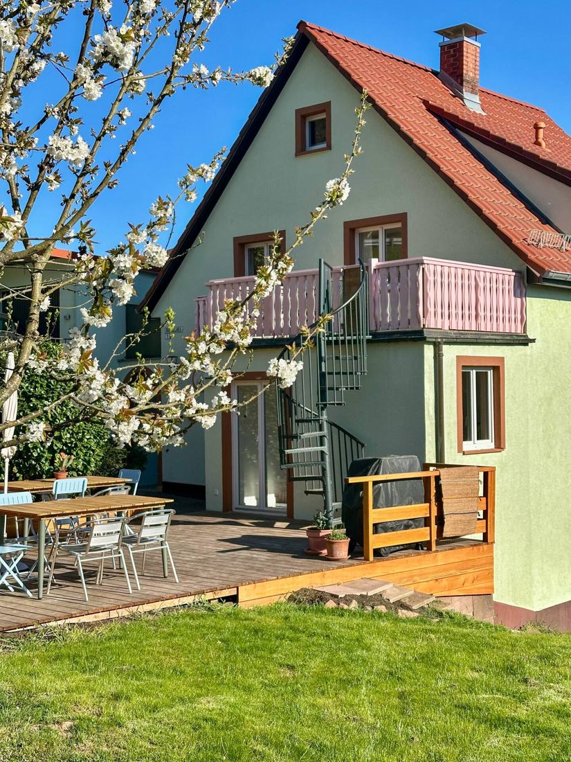 Terrasse mit Wendeltreppe unter einem blühenden Kirschbaum