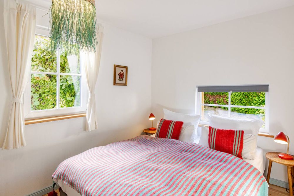 Schlafzimmer mit rot-türkis gestreifter Decke